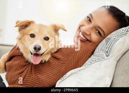 Non ho mai bisogno di nessun altro. Ritratto di una bella giovane donna che si rilassa sul divano con il suo cane a casa. Foto Stock