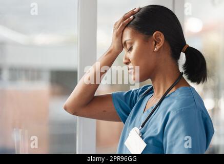 Il suo lavoro stressante è responsabile della vita, un medico giovane che guarda angosciato. Foto Stock