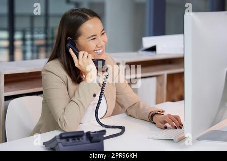 Youve ha chiamato la società giusta, una giovane donna che usa un telefono e un computer in un ufficio moderno. Foto Stock