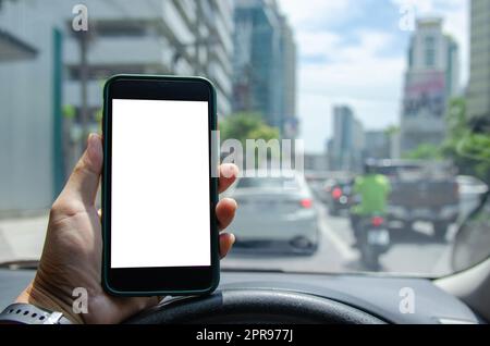 uomo che tiene smartphone mobile mock up display bianco in auto. Foto Stock