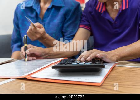 Asian anziani in possesso di penna contratto di pagamento carta di credito assicurazione assistenza sanitaria documenti o documento rapporto shopping finanza concetto. Foto Stock