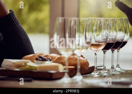 Im qui per assaggiare alcuni vini incredibili. Un uomo che si gusta un piatto di formaggi e degusta vini diversi. Foto Stock