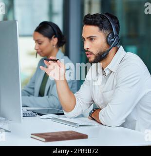 Il loro servizio veloce ed efficiente è apprezzato dai loro clienti, due uomini d'affari che lavorano in un call center. Foto Stock