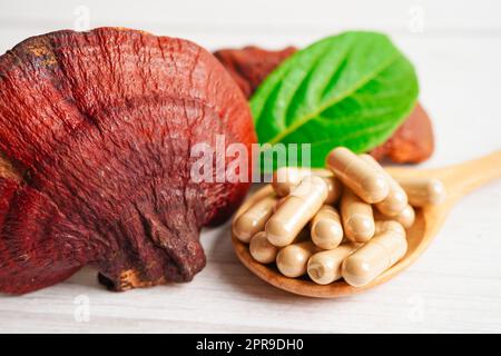 Lingzhi o Reishi funghi con capsule, alimenti biologici naturali sani. Foto Stock