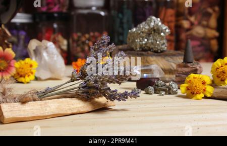Lavanda secca su bastoncini Palo Santo con cristalli e fiori sullo sfondo Foto Stock
