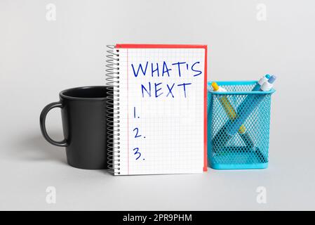 Ispirazione che mostra il segno What S is Next. Vetrina aziendale che chiede cosa succede subito dopo la presentazione di una tazza, notebook con messaggio importante e portamite sulla scrivania Foto Stock