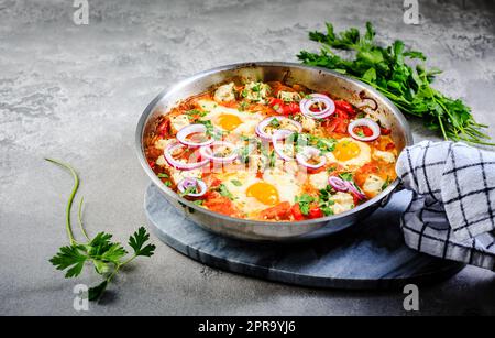 Shakshouka - uova in camicia in salsa di pomodori, peperoni, cipolla e formaggio feta. Pasto keto e carb basso Foto Stock