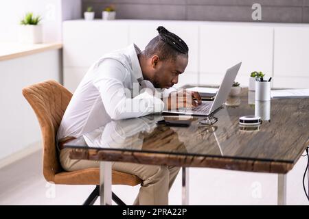 African Man Bad posture working typing Foto Stock