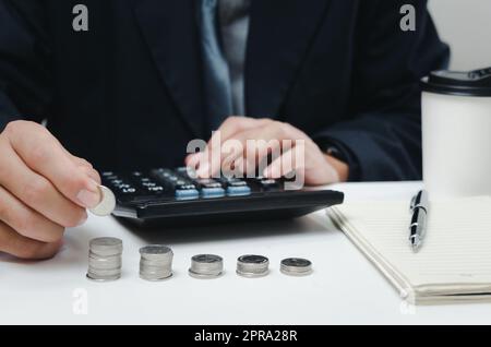 uomo d'affari uomo d'affari usa calcolatore moneta tassa finanziaria e investimenti di pianificazione economia di marketing reddito e risparmio di pensione. Foto Stock