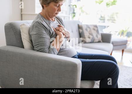 Donna anziana con dolore cardiaco che tiene il petto Foto Stock