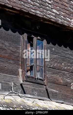 Vecchia casa di legno con finestra rotta Foto Stock