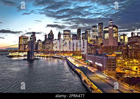 Vista dello skyline del centro di New York e del ponte di Brooklyn al tramonto Foto Stock