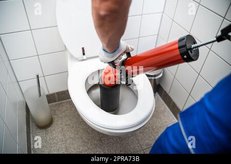 Wc riparare a mano con un wc stantuffo. Impianti idraulici. Un idraulico  utilizza uno stantuffo per sbloccare un wc. Servizi igienici stantuffo Foto  stock - Alamy