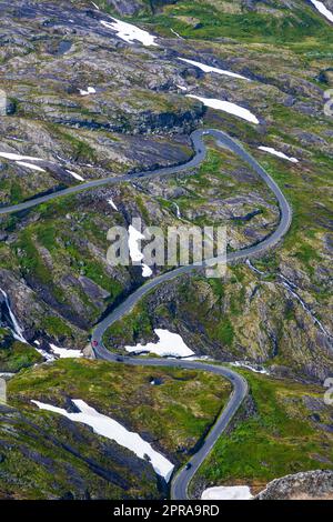 Paesaggio verde con macchie di neve e una strada tortuosa vista in Norvegia Foto Stock