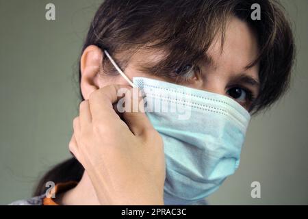 Ritratto di una ragazza che indossa una maschera medica protettiva. Foto Stock