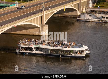 PRAGA, REPUBBLICA CECA - la barca turistica passa sotto Stefanikuv Most, il ponte di Stefanik, sul fiume Moldava. Foto Stock