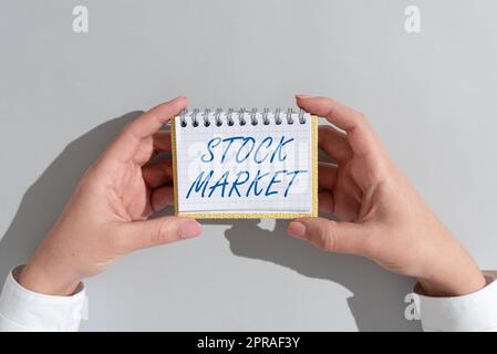 Didascalia di testo che presenta il mercato azionario. Approccio aziendale particolare mercato in cui vengono negoziate azioni di azioni e obbligazioni o scambio di informazioni a una donna d'affari che detiene un blocco note con un messaggio importante su Office Desk. Foto Stock