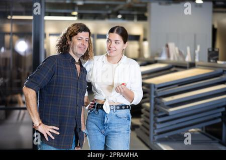 Donna e uomo che discutono della lista di shopping e che indicano qualcosa nel deposito Foto Stock