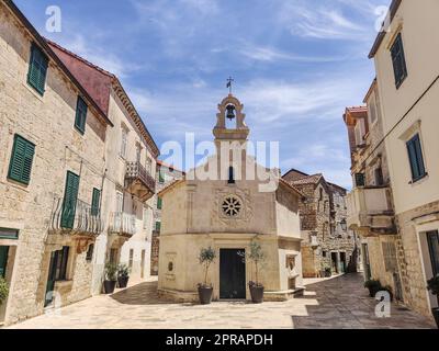 Piccola chiesa sulla piazza del piccolo villaggio urbano di Stari grad sull'isola di Hvar in Croazia, mare Adriatico, Europa. Foto Stock