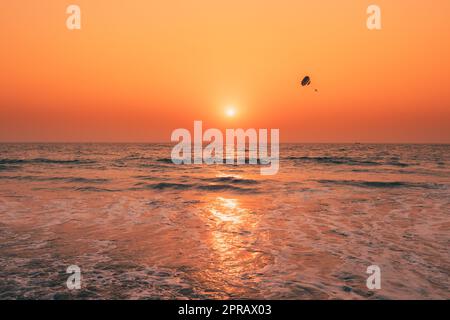 Tramonto Sole sopra Mare. Cielo naturale Alba colori caldi sul Mare di Ripple. Schiuma di acqua oceanica Lavaggio Sandy Beach al tramonto Foto Stock