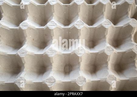 Vista dall'alto di un vassoio vuoto per uova di cartone struttura di fondo di un contenitore in un imballaggio di carta biodegradabile con un motivo ripetitivo Foto Stock