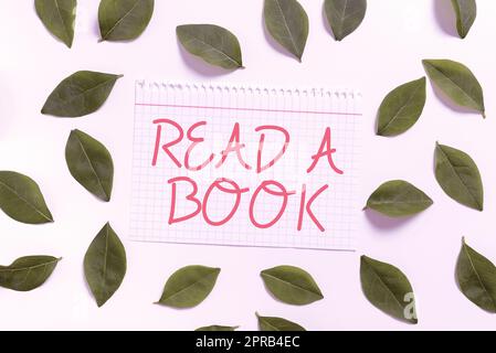 Cartello con la scritta leggi Un libro. Idea di business Godetevi la letteratura attività tradizionale Scoprite le novità Foglio notebook con nuove foglie per inviti e schede creative. Foto Stock