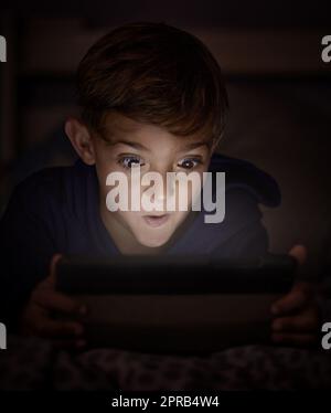 Muore troppo giovane quando arriva il wolfie, fee-fi-fo-fum. Adorabile ragazzino che utilizza un tablet digitale di notte. Foto Stock