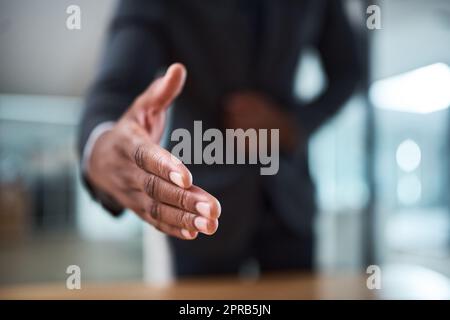 Piacere di conoscerti. un uomo d'affari irriconoscibile che estende una stretta di mano in un ufficio. Foto Stock