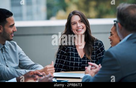 Si sente sempre ispirata quando lavora a fianco del suo fantastico team. una giovane donna d'affari che ha un incontro con i suoi colleghi sul balcone di un ufficio. Foto Stock