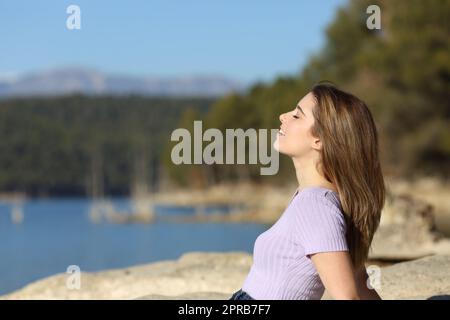 Adolescente rilassato che respira aria fresca in un lago Foto Stock