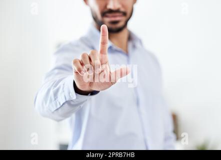 Uomo d'affari moderno, futuro e futuristico che punta il dito verso l'alto premendo un touchscreen virtuale vuoto. Ritratto di primo piano di un uomo professionista aziendale che tocca uno schermo invisibile o in ufficio Foto Stock