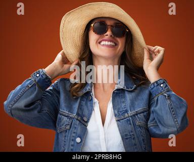 Per apparire bene, bisogna sentirsi bene. Studio girato di una giovane donna elegante che si posa su uno sfondo marrone. Foto Stock