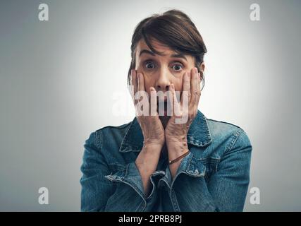 OH no, OH no, OH nooo. Studio girato di una donna anziana guardando scioccato su uno sfondo grigio. Foto Stock