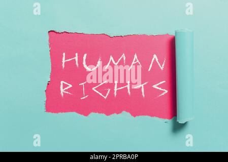 Cartello di testo che mostra i diritti umani. Parola scritta su principi morali standard norme di una mostra protetta dalla legge informazioni importanti scritte sotto un pezzo di carta strappato. Foto Stock