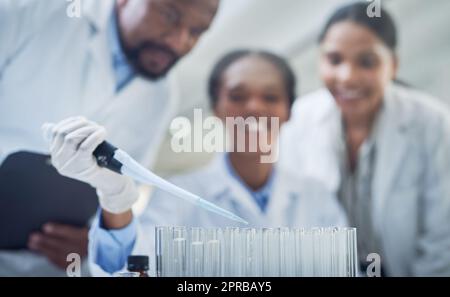 L'azione è il primo passo per trovare una cura: Un gruppo di scienziati che conducono la ricerca in un laboratorio. Foto Stock