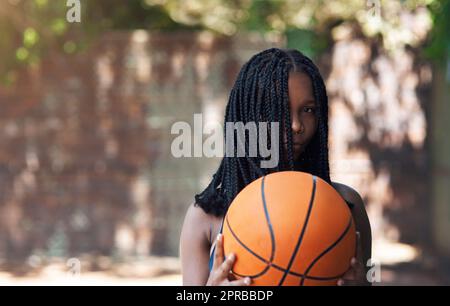 Indovinate le palle nel mio campo. Ritratto corto di una giovane atleta attraente in piedi sul campo di pallacanestro. Foto Stock