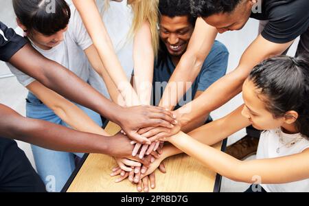 Il nostro team sarà il numero uno. Un gruppo di colleghi che si accovigliano le mani in un huddle di spirito di squadra. Foto Stock