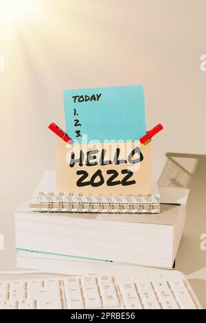 Didascalia concettuale Hello 2022. Panoramica aziendale sperando che si verifichi una grandezza per il prossimo anno messaggi importanti presentati su un pezzo di carta su scrivania con libri. Foto Stock