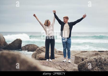 Stare con voi fa di tutto meglio: Una coppia che guarda allegra mentre passa il tempo in spiaggia. Foto Stock