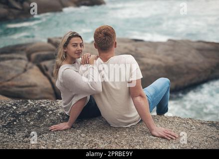 Ovunque con lui si sente speciale, una giovane coppia che trascorre la giornata insieme in spiaggia. Foto Stock