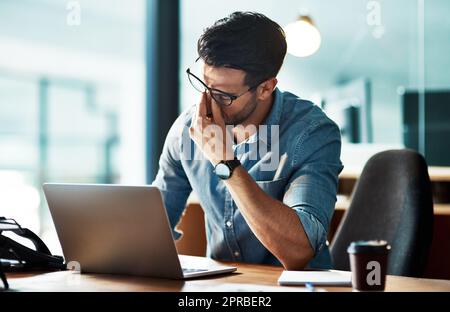 Uomo d'affari stressato, stanco e frustrato con mal di testa di notte a causa di esaurimento o errore sul notebook. Imprenditore creativo sovraccarico di lavoro che non riesce a rispettare la scadenza dell'ufficio tardiva o a lavorare in straordinari Foto Stock