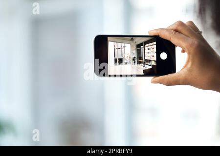 Lo strumento più intelligente per i tour a 360 gradi della proprietà. Una donna irriconoscibile che fotografa l'interno di una casa con uno smartphone. Foto Stock