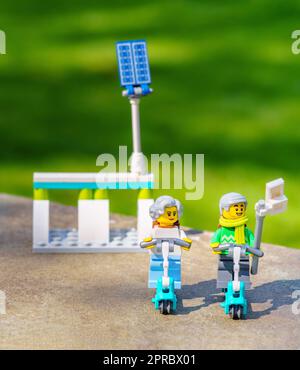 Coppia più anziana che cavalca gli scooter elettrici che prendono un selfie. Invecchiamento concetto migliore gli anziani attivi abbracciano la tecnologia, compreso il trasporto ecologico Foto Stock