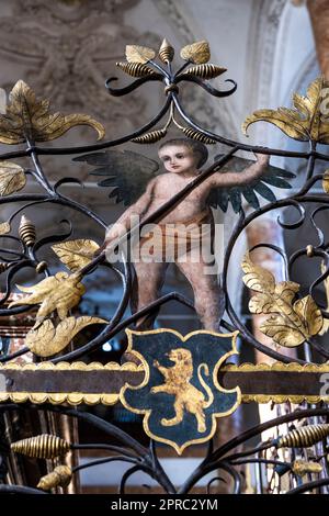 angelo e leone in piedi sul pannello in ferro battuto del cenotafio di Massimiliano i presso l'Hofkirche di Innsbruck in Austria Foto Stock