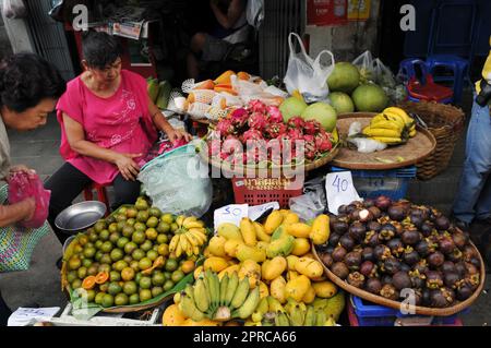 Un venditore di frutta al mercato Soi Prachum vicino Silom Road a Bangkok, Thailandia. Foto Stock