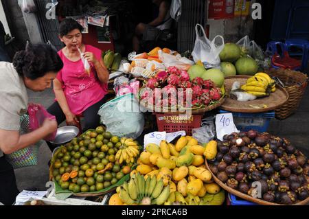Un venditore di frutta al mercato Soi Prachum vicino Silom Road a Bangkok, Thailandia. Foto Stock