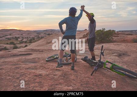 È stato epico. due uomini che si danno un alto cinque mentre fuori in mountain bike. Foto Stock