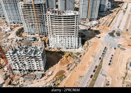 cantiere molto trafficato. complesso di alti edifici ad appartamenti in costruzione. vista aerea nelle giornate di sole. Foto Stock