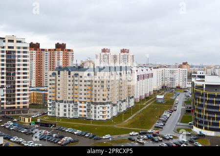 Vista dall'alto di una grande città moderna con case, edifici a più piani e architettura, parcheggio e molte auto. Foto Stock