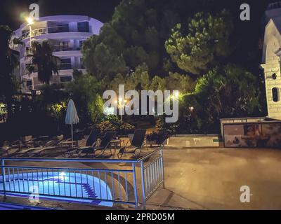 area salotto intorno alla piscina. riposatevi sull'acqua dell'hotel. grande area dell'hotel con acqua blu. notte in hotel. intrattenimento per i turisti. Foto Stock